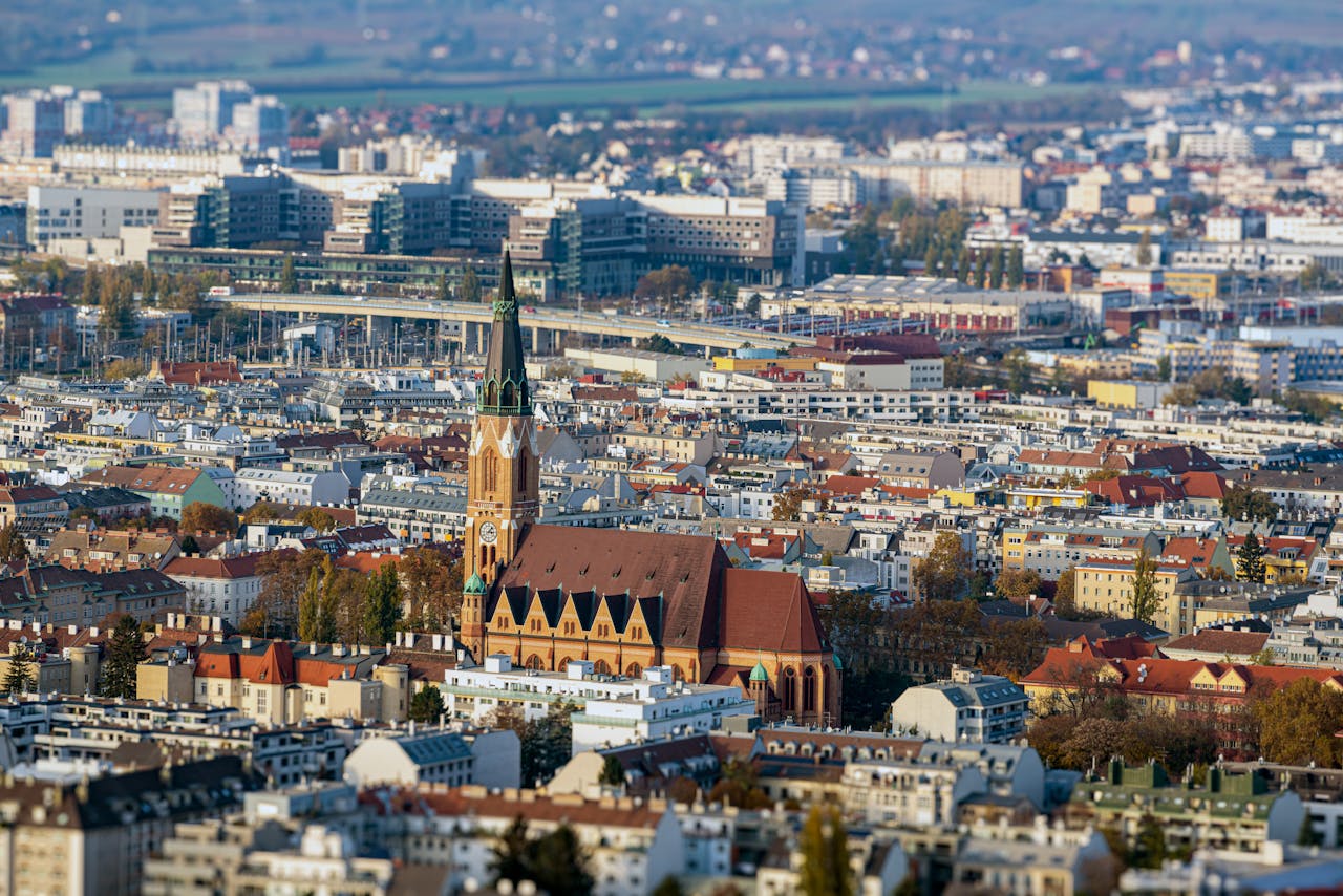 Stunning aerial view of Vienna showcasing historic church spire amidst cityscape.